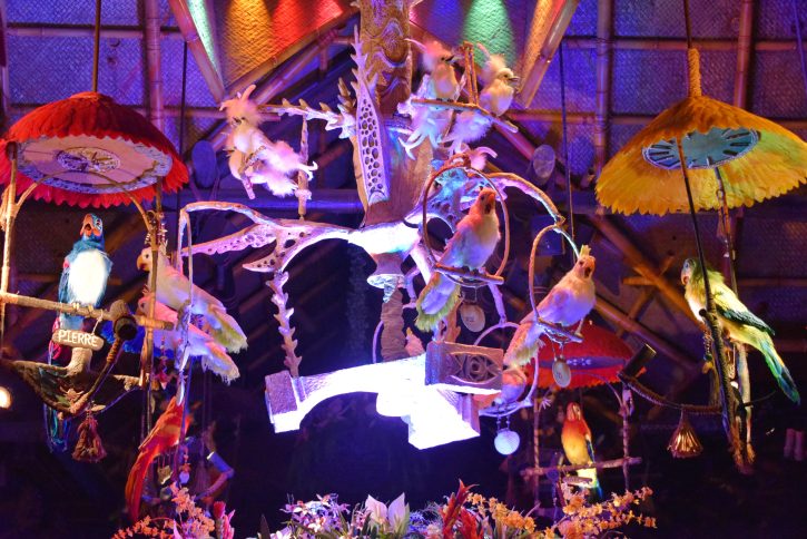 Image from the inside of the Enchanted Tiki Room of white birds on a perch descending from the ceiling.