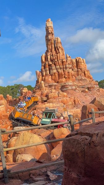 The main mountain peak of Big Thunder Mountain with a train car going down the track. 