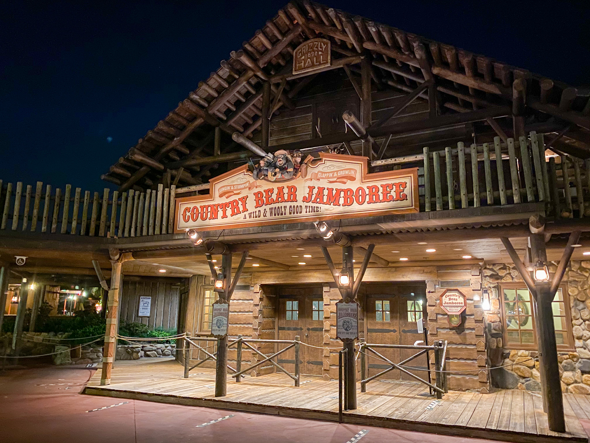Exterior of the Countree Bear Jamboree. THe sign is done in a Old Western style and the building looks like a log cabin.
