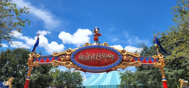 Image of the Sign outside of the enterance to the queue for Dumbo the flying Elephant. The sign reads Believe and Soar. Timothy Q Mouse stands on top of the sign. 
