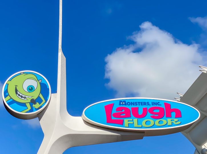 Image of the sign outside of Monster Inc., Laugh Floor. The sign includes a caricature of Mike Wazowski.