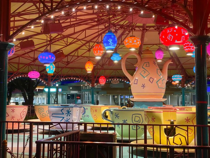 The inside of the Mad Tea Party Pavilion at night and lit up by many tea themed lights. 