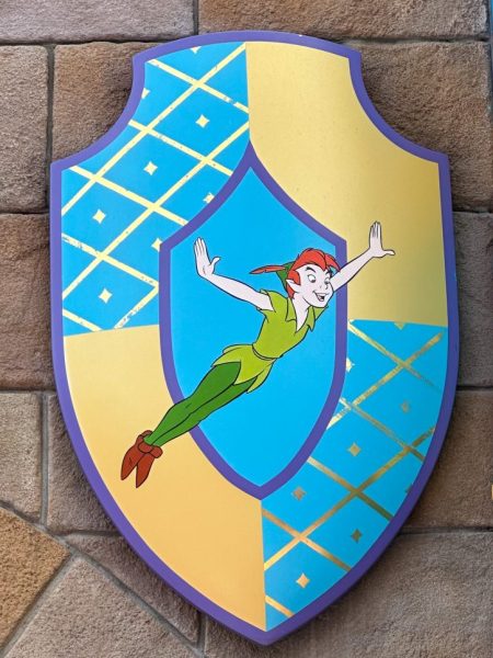 A colorful shield with peter pan depicted on the front.